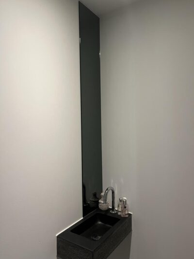Langer schmaler Spiegel über dem Waschbecken. In den Toilettenraum geklebt