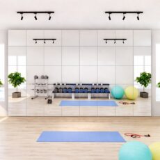 Mehrere kleine Sicherheitsspiegel, die direkt nebeneinander in einem Fitnessraum montiert sind.