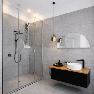 Halbrunder versilberter Spiegel in einem Badezimmer