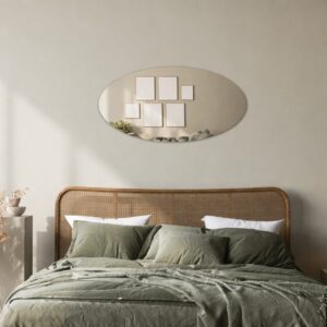 Bronzefarbener ovaler Spiegel an der Wand in einem grünen Schlafzimmer